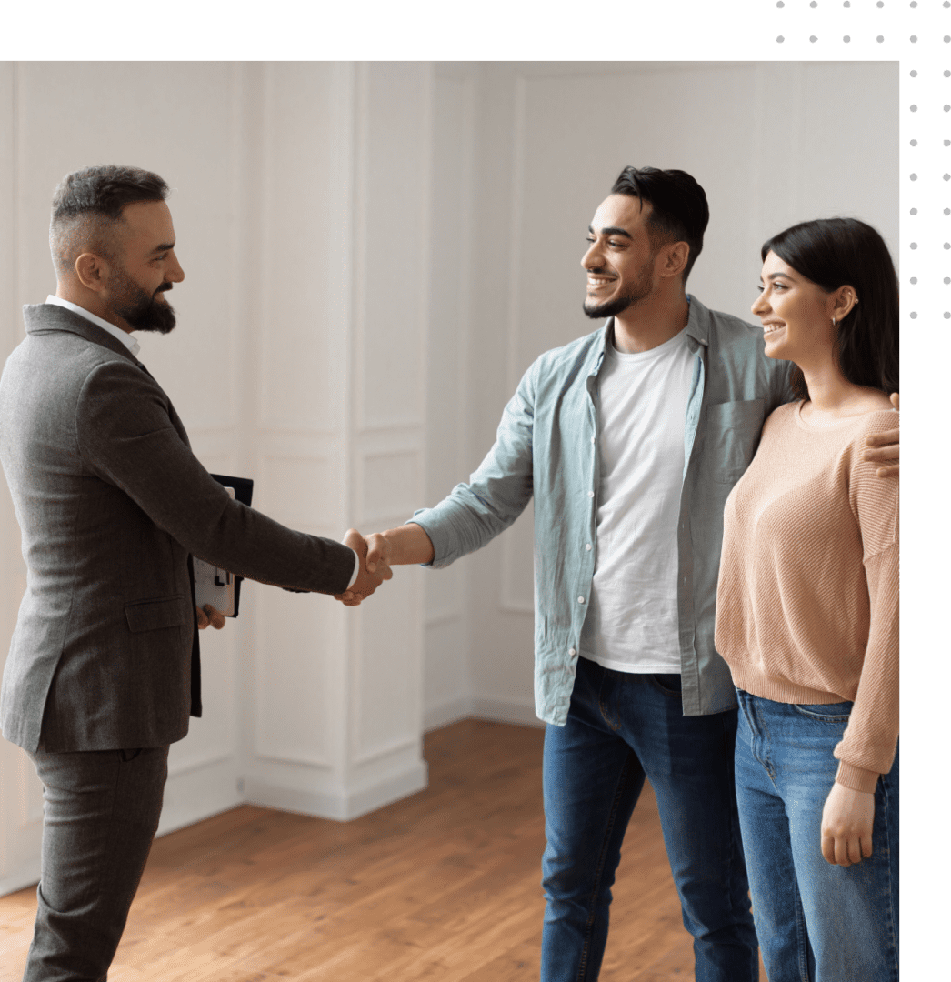 A man shaking hands with two women in front of him.
