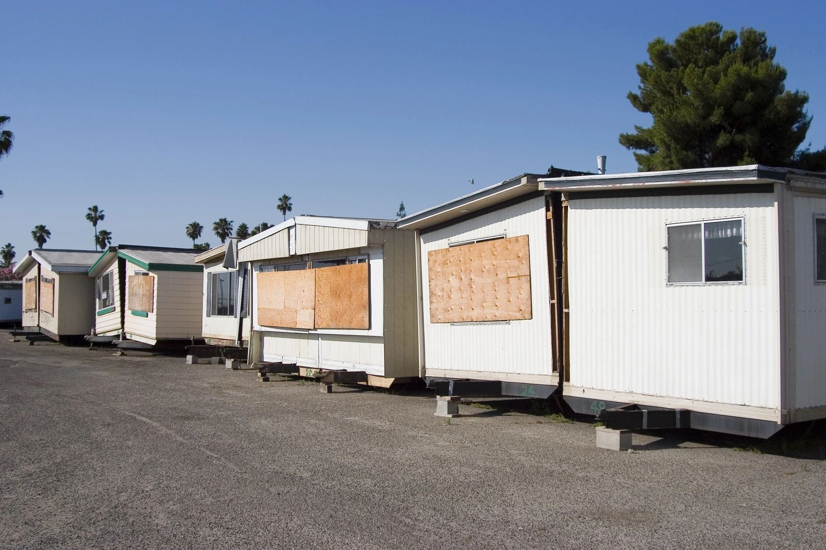 fm=f_108424 A row of mobile homes sitting on top of asphalt.